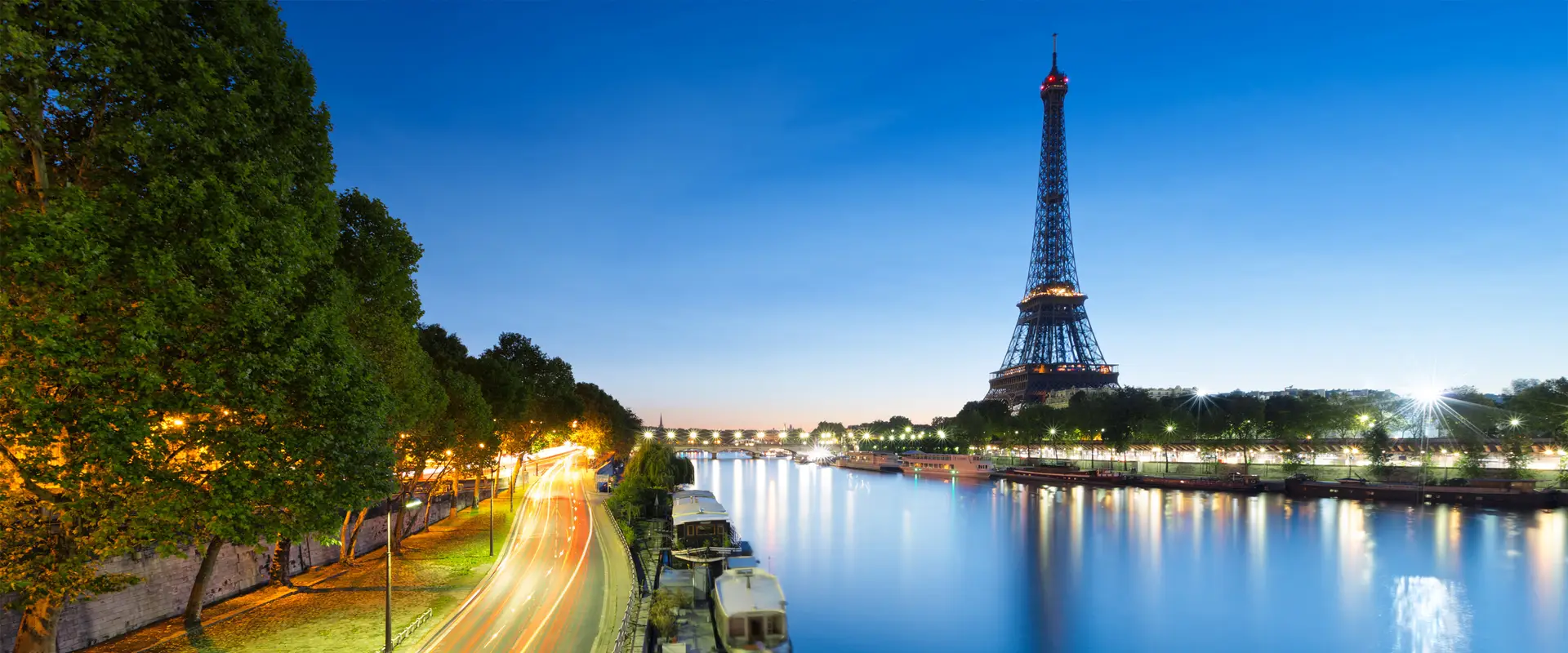 Eiffel Tower at Blue Hour Above a Riverside Light Trail