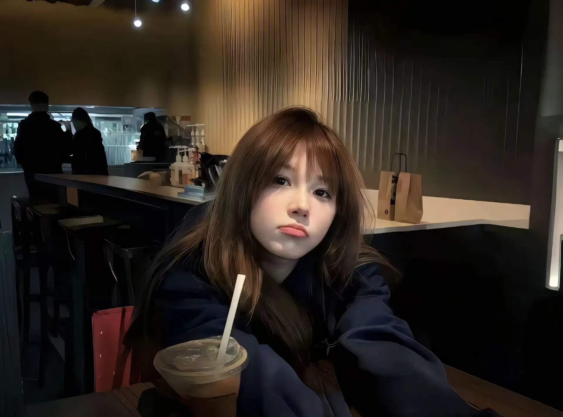 Brown-Haired Woman Gazing Across a Warmly Lit Cafe Table