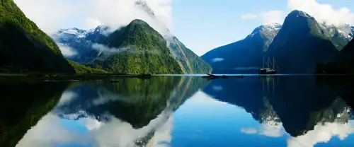 3840x1600 Ultrawide 自然风景 Wallpaper - 云雾雪山环抱蓝色湖湾与帆船镜面倒影